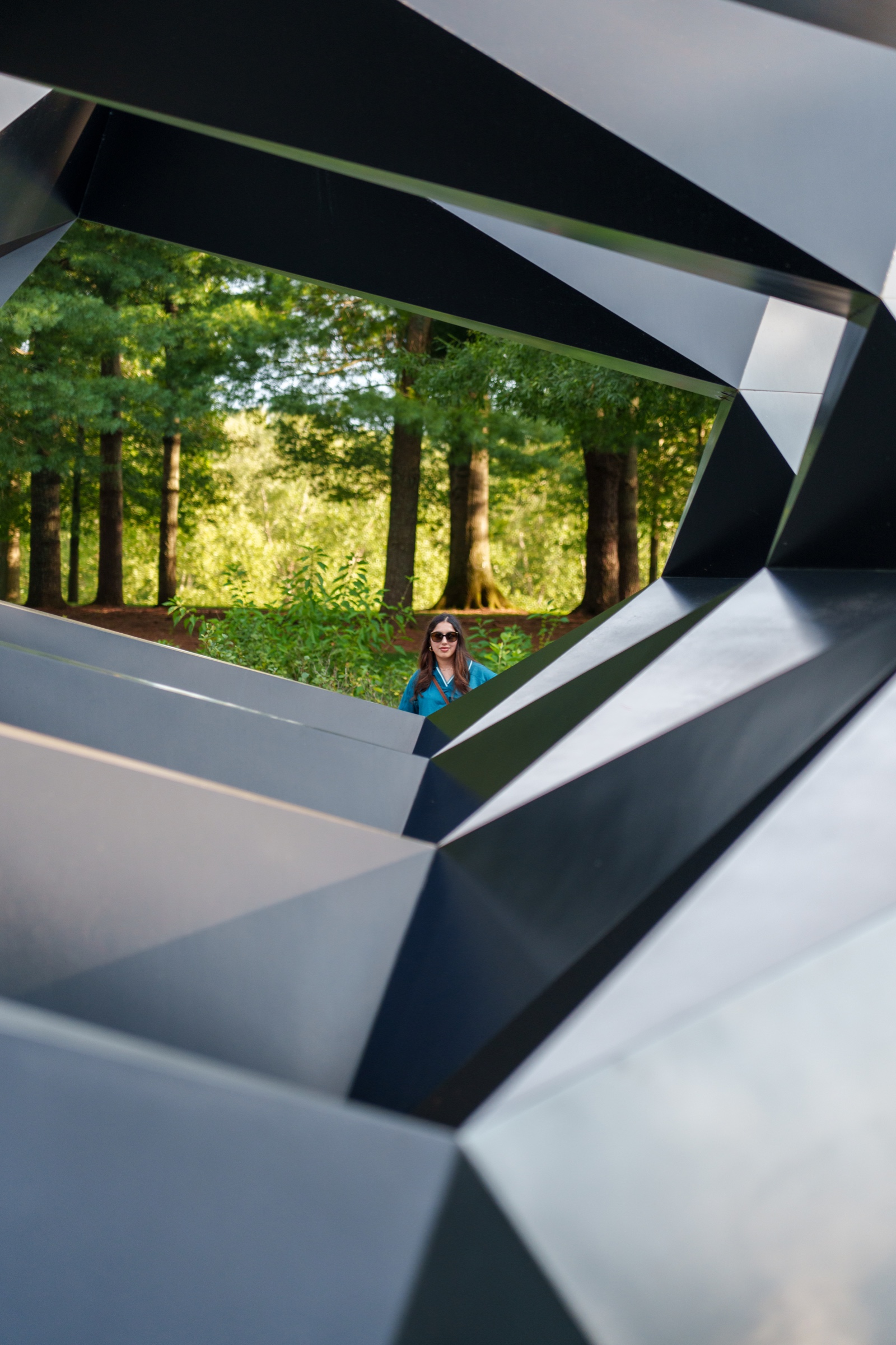 Editorial portrait framed through a geometric steel sculpture